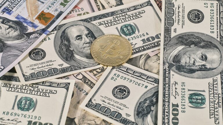 gold bitcoin on 100 dollar bills 768x432.jpg